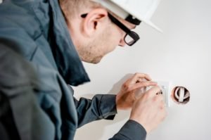 An electrician installs a residential electrical outlet